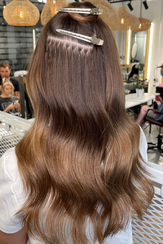 Frau mit braunen InterHair Extensions und Wellen